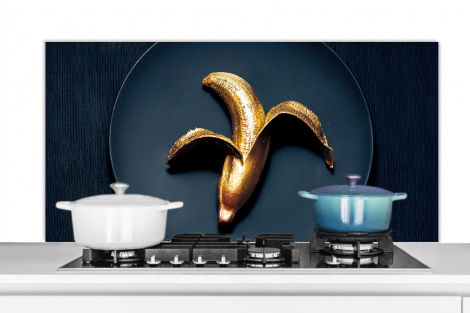 Spatscherm keuken - Gouden banaan op een donkere achtergrond