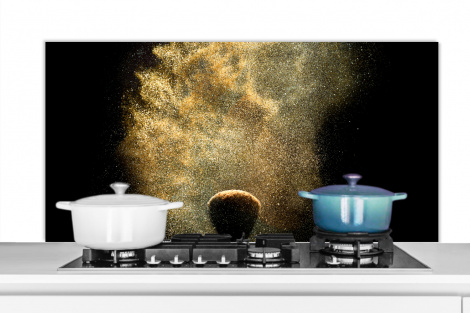 Spritzschutz Küche - Goldpulver auf schwarzem Hintergrund