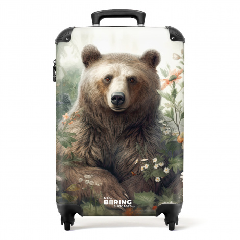 Koffer - Bruine beer zit tussen de bloemen en planten