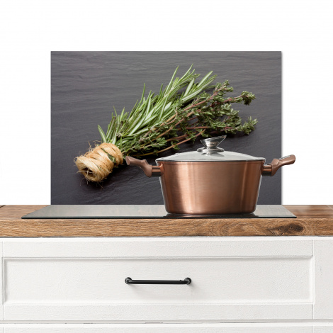 Spatscherm keuken - Een buideltje tijm op een donker houten tafel