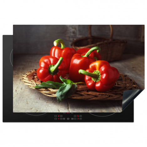 Inductie beschermer - Vier rode paprika's op een rieten mand