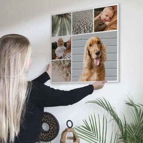 Fotocollage wordt aan de muur gehangen door een vrouw