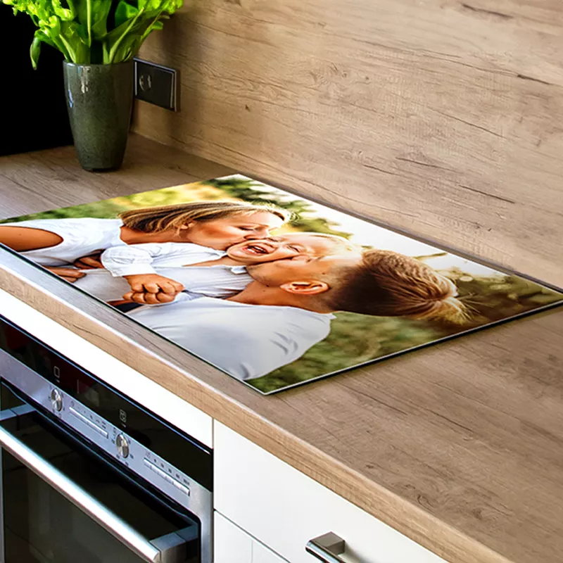 Een inductiebeschermer met eigen foto ligt op het fornuis