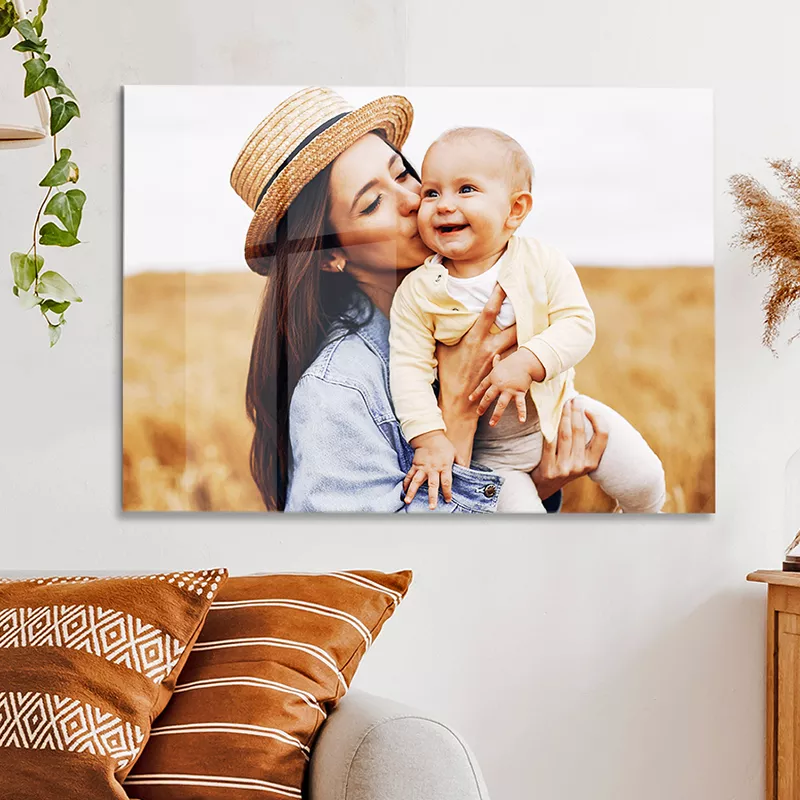 Een foto op plexiglas van een moeder met dochter hangt aan de wand