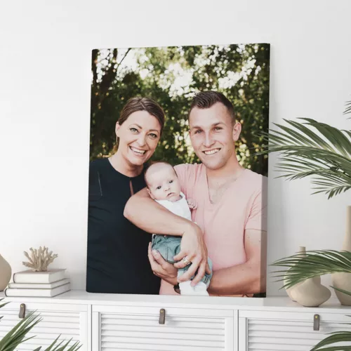 Een foto op canvas van een gezin op een witte kast