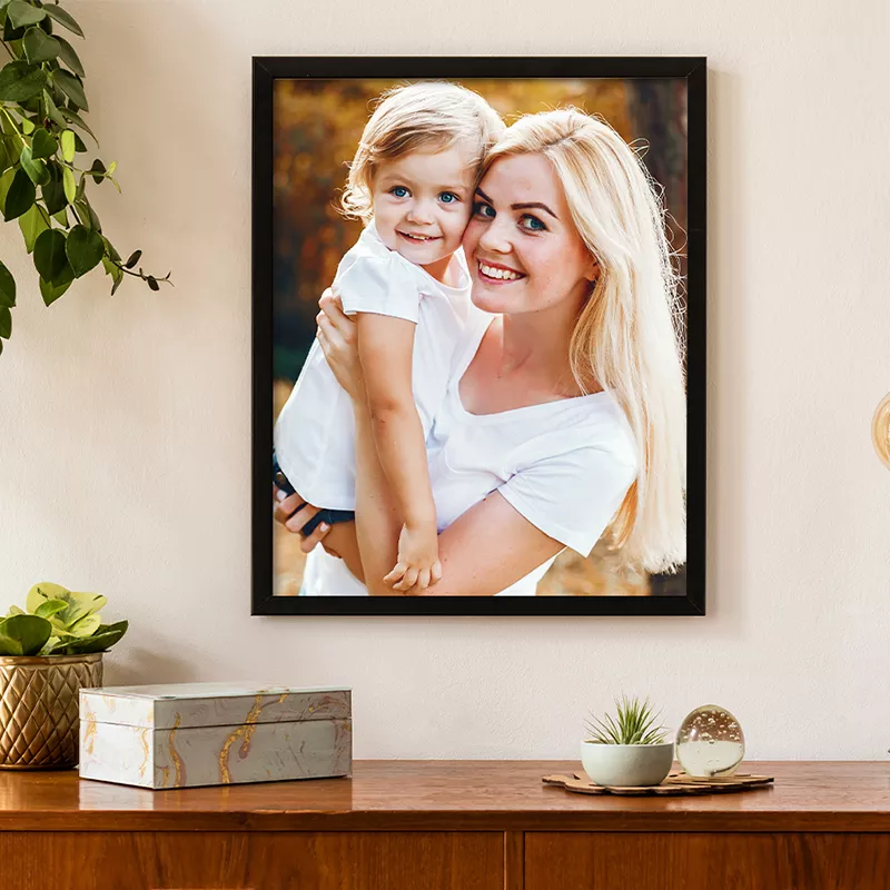 Een fotolijst van moeder en dochter hangt aan de wand