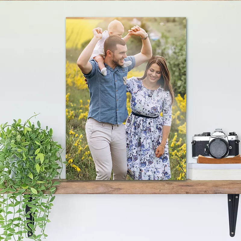 Een foto op aluminium van een gezin staat op een plank