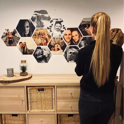 Een vrouw kijkt naar een hexagon collage die aan de muur hangt