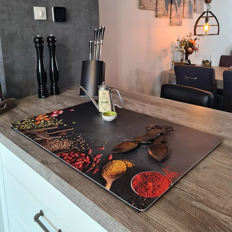 Een inductiebeschermer met rustieke print ligt op het fornuis